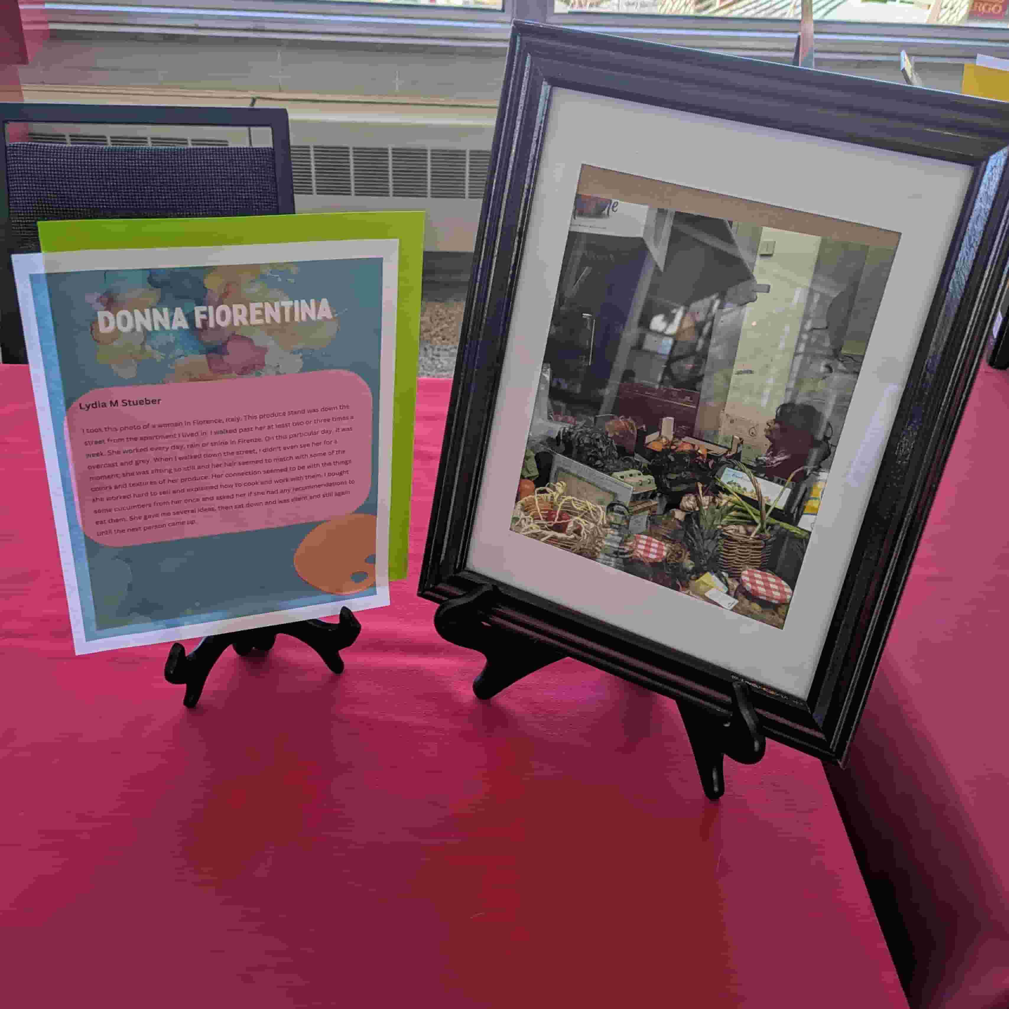 A photo in a frame of a woman at a fruit stand, there is a descriptive plaque next to the photo